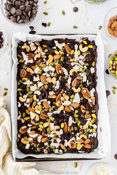 a chocolate cake with nuts and pistachios on top, surrounded by other ingredients