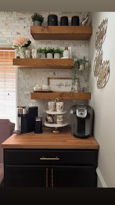 a coffee bar with shelves above it and cups on the top shelf, along with other items