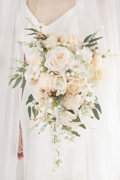 a bridal holding a bouquet of white flowers