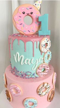 a birthday cake decorated with donuts and sprinkles for one year old