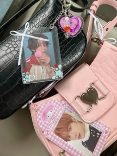 a pink purse with a photo on it and some other items attached to the bag