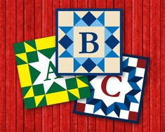 three different color blocks with the letter b and c in them on a red wood background