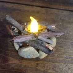 an image of a fire pit made out of wood and rocks on a wooden table