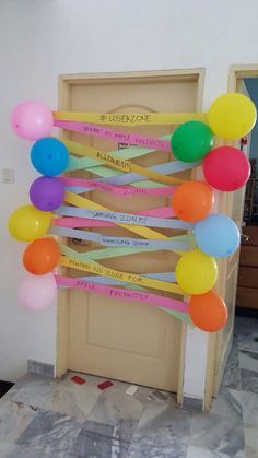 a bunch of balloons that are hanging from a door