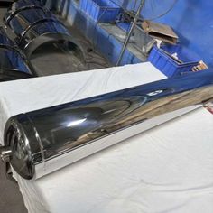 the back end of a large metal object on top of a white cloth covered table