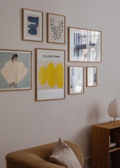 a living room filled with furniture and framed pictures on the wall above a table top