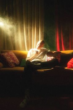 a person sitting on a couch in the dark