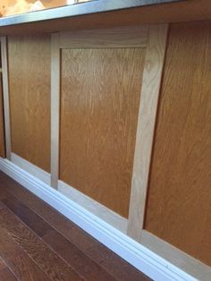 a kitchen counter with wooden paneling on it