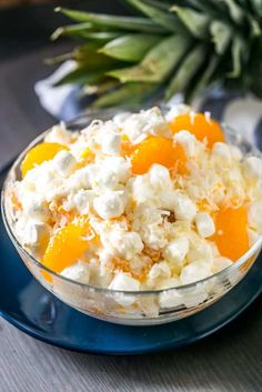 a bowl filled with oranges and cottage cheese on top of a blue saucer