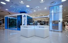 the interior of a retail store with two white counter tops and blue lights on the ceiling