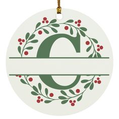 a christmas ornament with the letter q in green and red berries on it