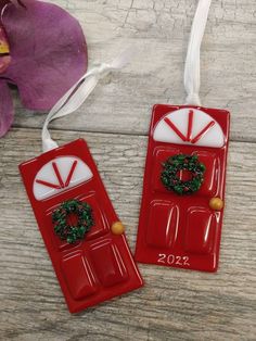 two red door ornaments with wreaths on them