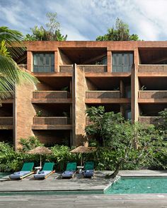 an outdoor swimming pool with lounge chairs next to it