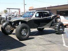 an off - road vehicle is parked in a parking lot with other cars behind it