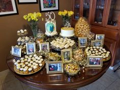 a table topped with pictures and cakes covered in frosted cupcakes on top of a wooden table