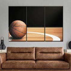 a basketball sitting on top of a wooden floor in front of a wall mounted canvas