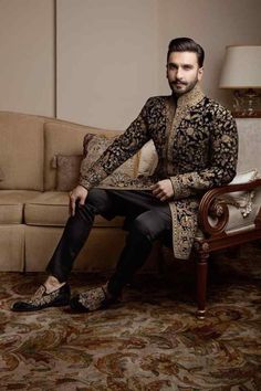 a man sitting on top of a couch next to a chair