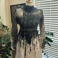 a dress on a mannequin with black paint splatters all over it