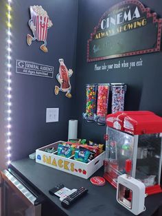 a table with some candy on it in front of a movie sign and neon lights