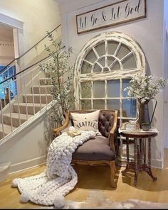 a living room with a chair, table and stairs