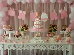 a table topped with lots of pink and white balloons next to a baby's cake