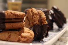 chocolate covered cookies on a plate next to a glass of orange juice