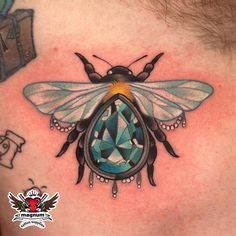 a man's chest with a bee and diamond tattoo design on the back of his neck