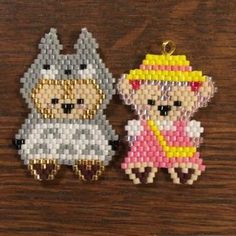 two beaded charms sitting on top of a wooden table