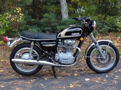 a black and silver yamaha motorcycle parked in front of some trees