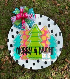 a merry and bright christmas ornament is on the grass with a polka dot bow