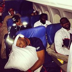 the men are sleeping on the airplane with their headphones in their ears and eyes closed