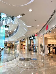 the inside of a shopping mall with spiral staircases and glass doors on both sides