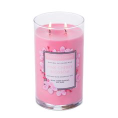 the pink cherry blossom candle is in a glass container