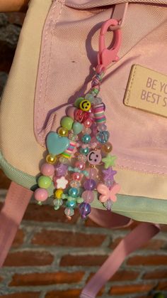 a pink backpack with a bunch of beads hanging from it's back pocket and the words, be you best friend