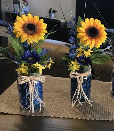 three mason jars with sunflowers and blue flowers in them