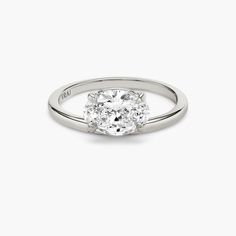 a diamond ring on a white background with the center stone in the middle and two diamonds at the bottom