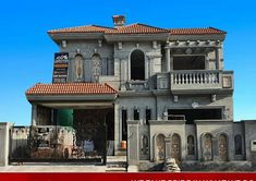 a large gray house with red tile roof