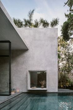 an outdoor swimming pool next to a concrete building