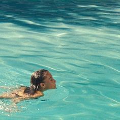 a woman swimming in the water with a frisbee