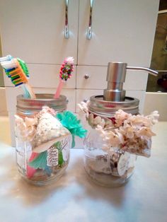 two mason jars with toothbrushes in them sitting on a counter