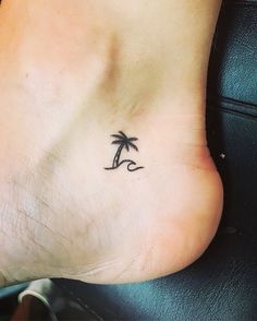 a small palm tree tattoo on the bottom of a person's foot is shown