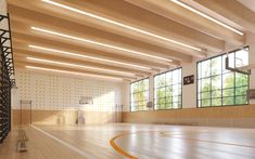 an empty basketball court with wooden floors and large windows in the center is surrounded by wood paneling