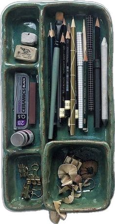 a green container filled with lots of different types of pens and pencils