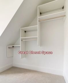 an empty room with white closets and open shelving unit on the wall, in front of a slanted ceiling