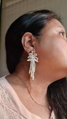 "Handmade statement Ivory pearl and gold chain floral long earrings. These handmade statement earrings are made of faux pearl flower, and electroplated rose gold chain fringes. The earrings are beautiful and ideal for weddings and parties. The earrings measures approx. 4\" long and 1\" wide. Carnation jewellery are purely handmade & handcrafted in India. Since our product is purely handmade in nature hence a slight imperfection may be there but it is almost negligible. The colors and may slightl Gold Tassel Earrings For Wedding, White Chandelier Earrings With Pearl Chain For Party, Elegant Pearl Earrings With Latkans For Party, Elegant Wedding Tassel Earrings With Latkans, White Dangle Bridal Earrings With Pearl Chain, Gold Pearl Drop Tassel Earrings For Wedding, White Pearl Drop Dangle Tassel Earrings, White Dangle Tassel Earrings With Pearl Drop, White Pearl Embellished Dangle Bridal Earrings