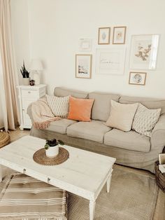 a living room filled with furniture and pictures on the wall