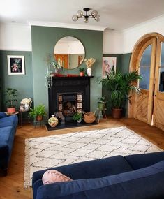 a living room filled with furniture and a fire place under a mirror on the wall