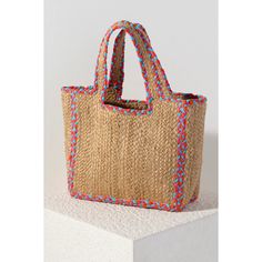 Carry your essentials in style this summer with this Natural Liv Tote. This classic woven jute bag features double handles and a vibrant pink and blue braided outline. This elegant pop of color will match with any outfit, and its large size is perfect for whatever warm weather activities you have in store. Details • Made in India • Dimensions: 11.5 x 6 x 10 in (29.2 x 15.2 x 25.4 cm) Multicolor Straw Bag For Spring, Spring Multicolor Straw Bag With Handles, Spring Braided Jute Beach Bag, Multicolor Jute Crochet Bag For Shopping, Spring Pink Straw Bag With Braided Handles, Pink Straw Bag With Braided Handles For Spring, Pink Spring Straw Bag With Braided Handles, Multicolor Jute Crochet Bag With Braided Handles, Blue Jute Bags For Summer