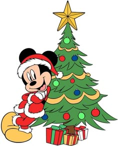 mickey mouse standing next to a christmas tree