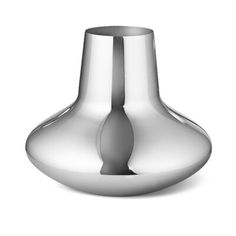 a silver vase sitting on top of a white surface